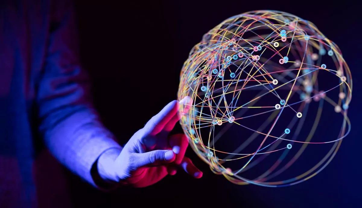 A hand reaching toward a glowing globe of interconnected 5G network nodes